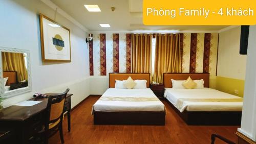 a hotel room with two beds and a desk at Linh Phuong 8 Hotel - 24 hours stay in Can Tho