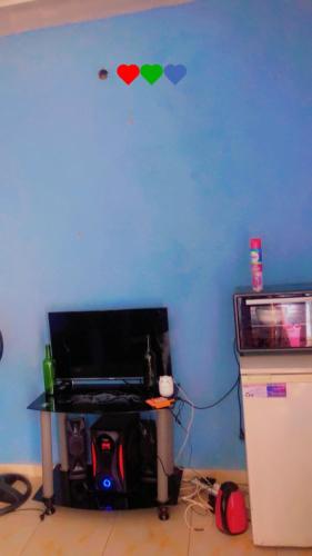 eine blaue Wand mit einem Tisch und zwei Herzen an der Wand in der Unterkunft K House in Kampala
