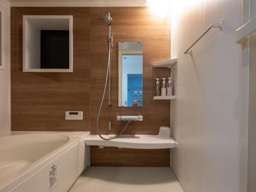 a bathroom with a tub and a sink and a mirror at Sumiyoshi Marie - Vacation STAY 12161 in Osaka