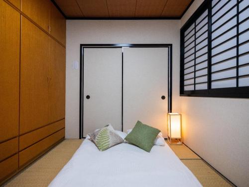 a bedroom with a bed with a window and a door at Sumiyoshi Marie - Vacation STAY 12161 in Osaka