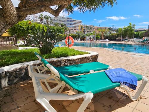 une chaise longue à côté de la piscine dans l'établissement PaulMarie Apartment Playa La Arena, à Puerto de Santiago