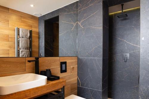 een badkamer met een wastafel en een spiegel bij Apartament Old Street in Zakopane