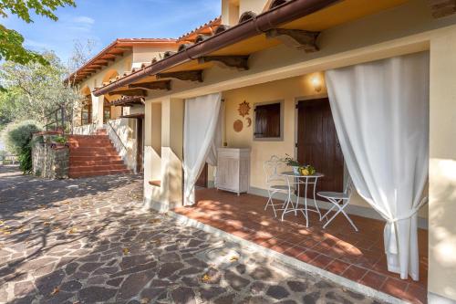 une maison avec un patio avec une table et des chaises dans l'établissement Tuscany Tuscany Villa And Apartment with Private Pool & Tennis, à Case Malva
