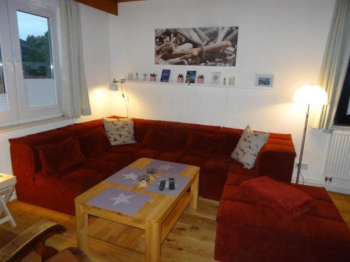 a living room with a red couch and a table at Ferienhaus Urlaub am Meer in Maasholm-Bad