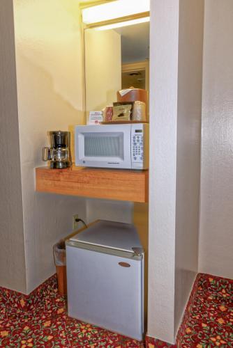 a microwave sitting on a shelf next to a refrigerator at Grand Vista Hotel Grand Junction in Grand Junction