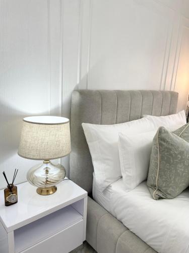 a bed with a lamp on a night stand next to a side table at Privately Owned Apartment at Ocean View Villas in Port Edward