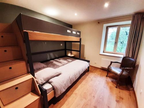 ein Schlafzimmer mit einem großen Bett und einem Stuhl in der Unterkunft Le Cottage in Sorans-lès-Breurey