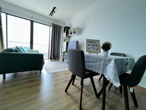 a living room with a table with chairs and a couch at 1-5 Pax Comfy Trefoil Studio-Walk to Setia City Mall & Setia City Convention Centre in Shah Alam