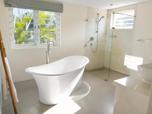 a white bathroom with a tub and a shower at Beehaven Sunset Paradise in Kenton on Sea