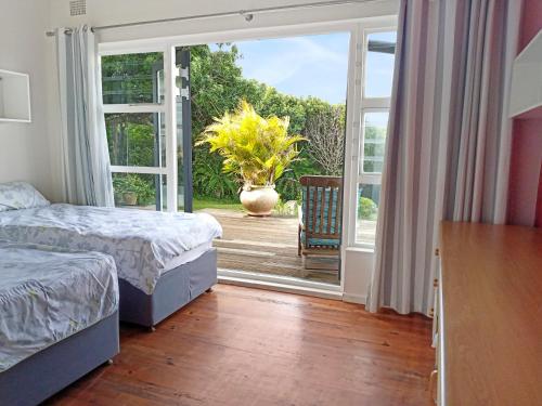 una camera con 2 letti e una porta scorrevole in vetro di Beehaven Sunset Paradise a Kenton-on-Sea