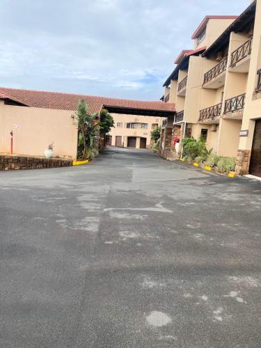 an empty parking lot in front of a building at Privately Owned Apartment at Ocean View Villas in Port Edward