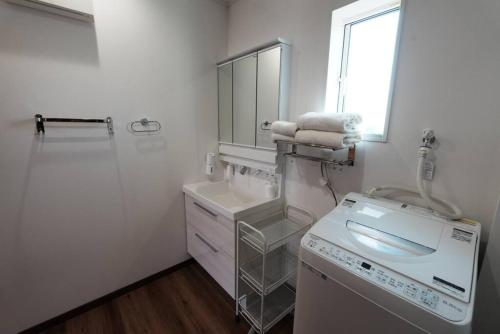 Baño blanco con lavabo y espejo en 【 STAY Chill ~omura~】長崎空港から車で10分！, en Omura
