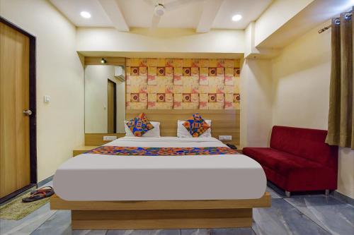 a bedroom with a large bed and a red couch at FabHotel Vishala in Ahmedabad