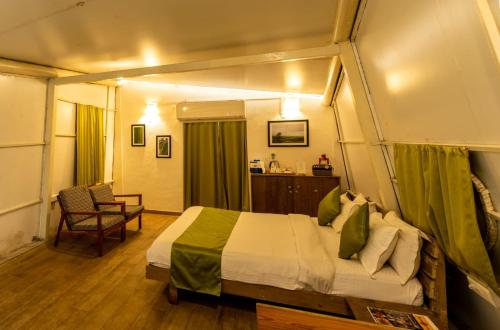 een slaapkamer met een bed en een stoel in een kamer bij Touchwood Bliss Igatpuri in Nashik