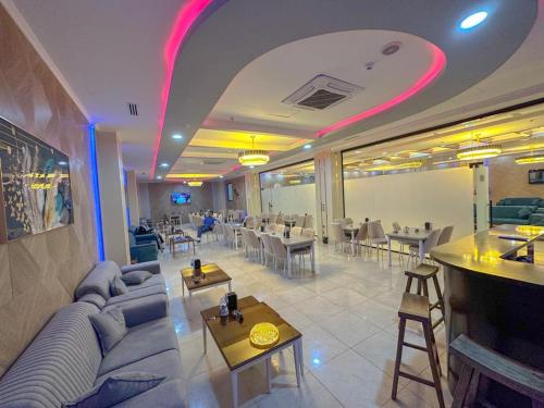 a restaurant with a couch and tables and a bar at Hotel Chanel Plaza in Erbil