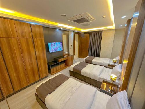 a hotel room with two beds and a flat screen tv at Hotel Chanel Plaza in Erbil