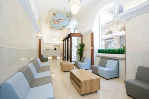 uma sala de espera com cadeiras azuis e uma mesa em Hotel Maximus em Roma