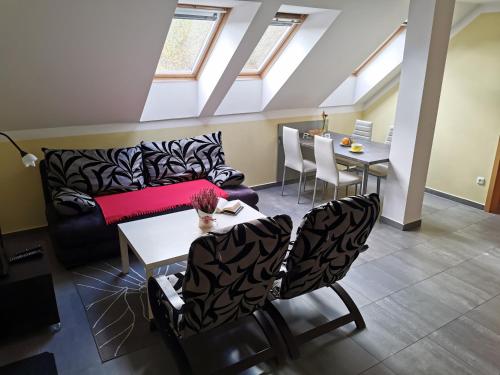 - un salon avec un canapé, une table et des chaises dans l'établissement Penzion Vincent, à Dolní Moravice