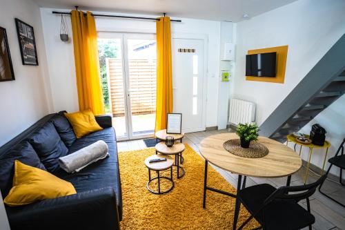 ein Wohnzimmer mit einem blauen Sofa und einem Tisch in der Unterkunft LE GABRIELE de PESSAC in Pessac