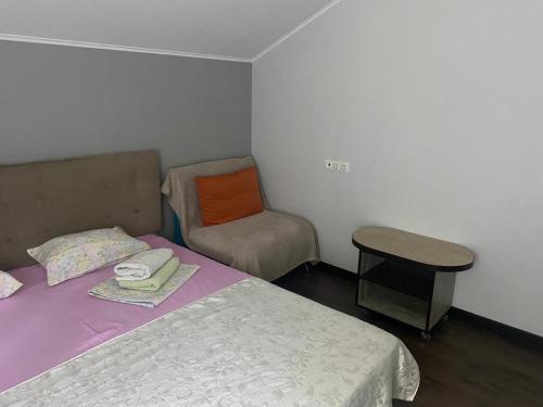a small bedroom with a bed and a chair at Дом in Kyiv
