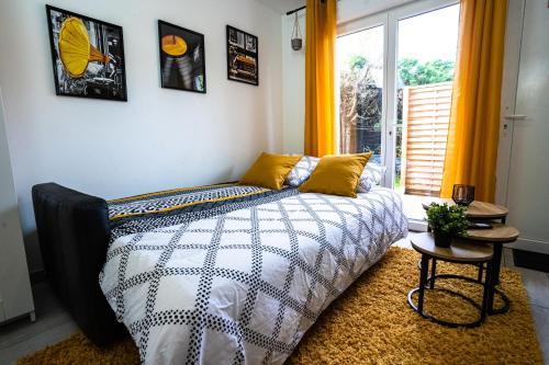 - une chambre avec un lit doté de rideaux jaunes et d'une fenêtre dans l'établissement LE GABRIELE de PESSAC, à Pessac