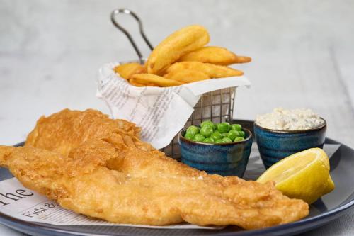 a plate of fish and french fries and a basket of peas at The Cricket Inn in Beesands