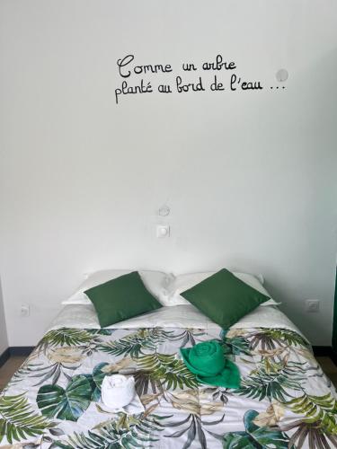 La Maison Verte في لو تامبون: غرفة نوم مع سرير مع علامة على الحائط
