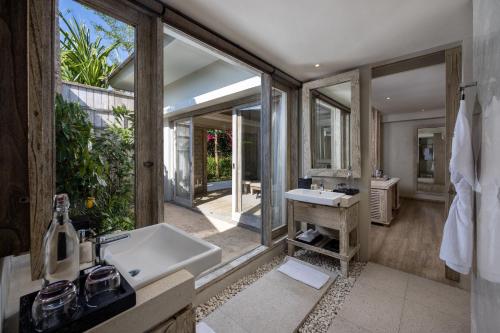 a bathroom with a sink and a large window at Cross Bali Breakers in Jimbaran