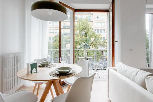 ミラノにあるLuxury 2 bedroom Apartament, close to San Siro, Fiera and 10 min metro to Duomoの白いリビングルーム(テーブル、椅子付)