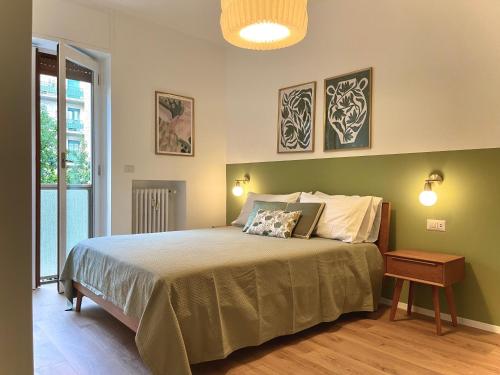 a bedroom with a bed with a green wall at Luxury 2 bedroom Apartament, close to San Siro, Fiera and 10 min metro to Duomo in Milan