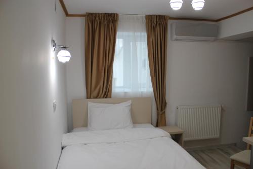 布加勒斯特的住宿－Hotel Marina srl，一间卧室设有两张白色的床和窗户