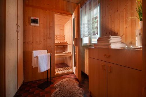 a bathroom with wooden walls and a window and towels at Karolinka Holiday Homes in Karolinka