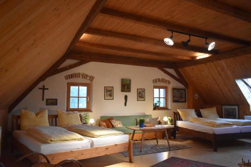 a attic room with two beds and a couch at Plaunerhaus 47 in Sankt Marein bei Graz