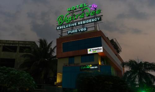 a building with a neon sign on top of it at Treebo Trend Bhairavee in Pune