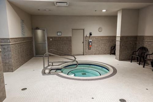 a hot tub in a bathroom with a chair at Sunset Waterfront Resort #1306 in Kelowna