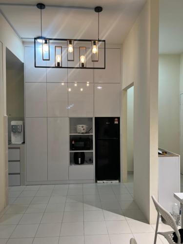 a kitchen with a black refrigerator and a chandelier at Borneo Cove Seaview Sandakan in Sandakan