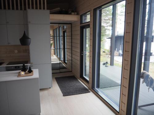 a kitchen with a large sliding glass door to a yard at Scandinavian lakeside cottage in Rovaniemi