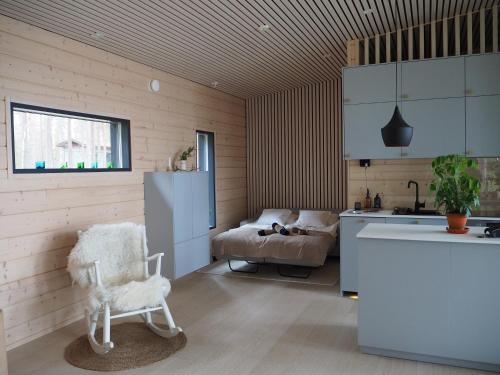 a kitchen with a chair and a couch in a room at Scandinavian lakeside cottage in Rovaniemi