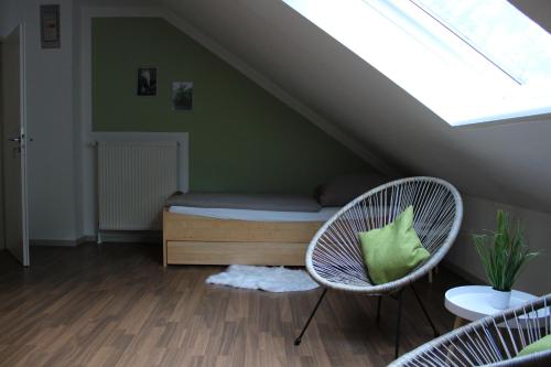 um quarto no sótão com uma cama e 2 cadeiras em Ferienwohnung unter den Eichen em Schwanewede
