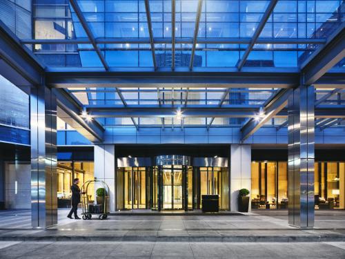 a man walking into a large glass building at Grand ParcVue Hotel Residence Chengdu in Chengdu