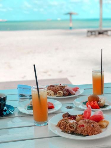 a table with plates of food and drinks on the beach at Viovio Beach & Resort in Sinyantung