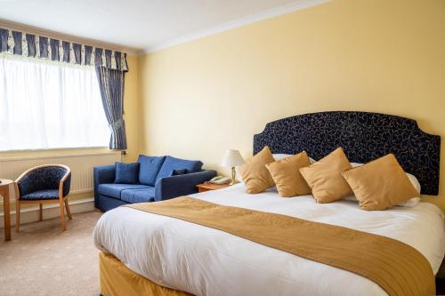 a bedroom with a large bed and a blue chair at Tiverton Hotel Lounge & Venue in Tiverton