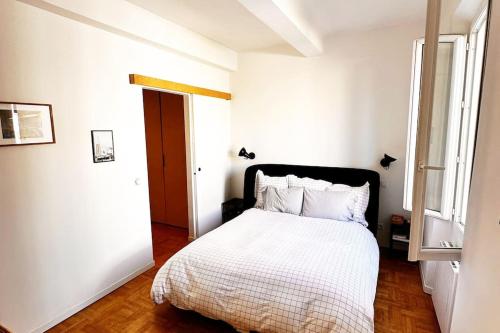 une chambre blanche avec un lit et une fenêtre dans l'établissement Magnifique Nid douillet au Cœur Marseille Reformés, à Marseille