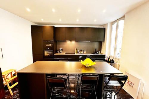 une cuisine avec une table, des chaises et une boîte jaune. dans l'établissement Magnifique Nid douillet au Cœur Marseille Reformés, à Marseille