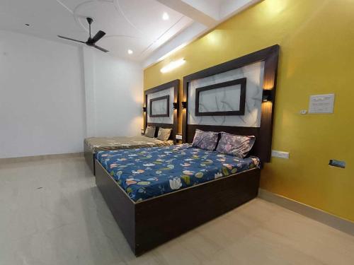a bedroom with a bed and a tv on the wall at Hotel O Maa Yashodha Palace in Ayodhya