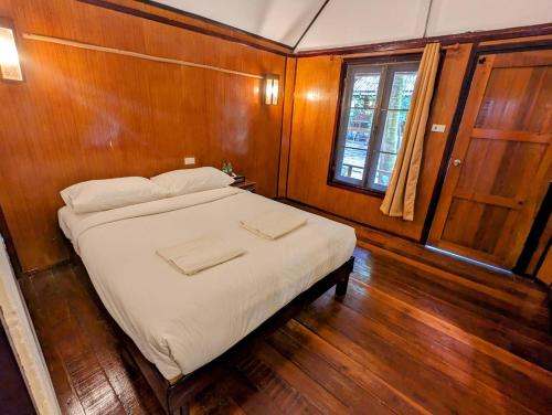 - une chambre avec un lit doté de draps blancs et une fenêtre dans l'établissement Ziggy Stardust, à Ko Phayam