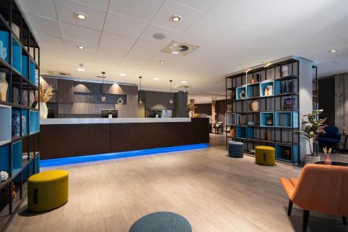 een bibliotheek met een bureau, stoelen en boekenplanken bij Bilderberg Europa Hotel Scheveningen in Scheveningen