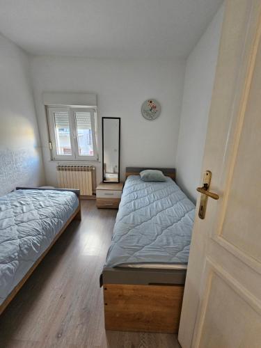 a bedroom with two twin beds and a door at St Anthony's House with Parking in Zagreb
