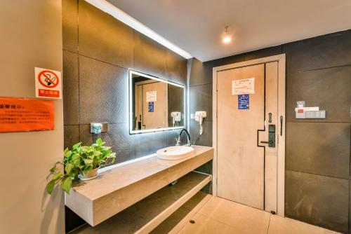 a bathroom with a sink and a mirror at Yangshuo EMOJI YOUTH HOSTEL in Yangshuo