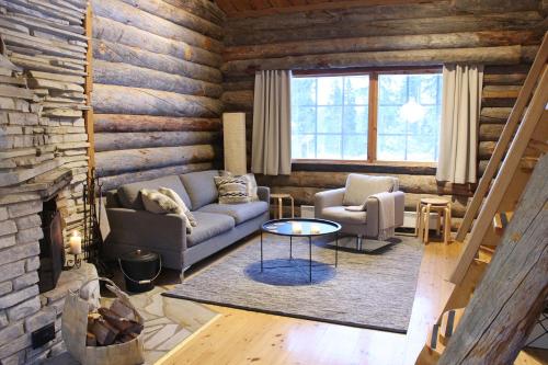 uma sala de estar com um sofá e uma mesa em Lapland Cabin Vonkamies em Luosto